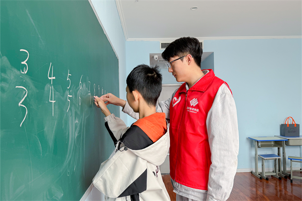 01 圖為志愿者教特殊兒童寫(xiě)數(shù)字